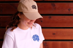 Eine beige Cap mit dem Logo von PsychOlympia